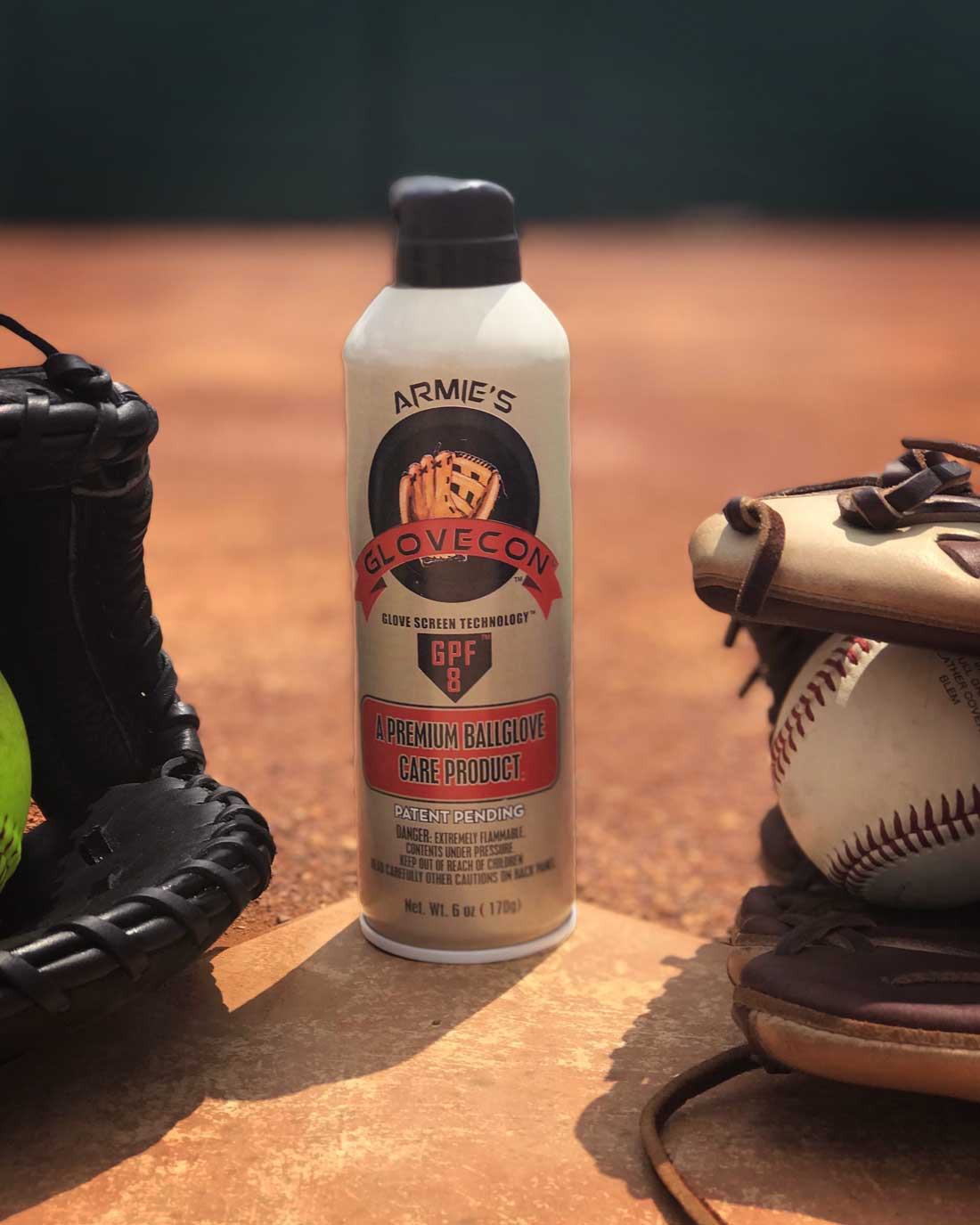 Premium baseball glove cleaner aerosol can hero image set on home plate between two baseballs and gloves.